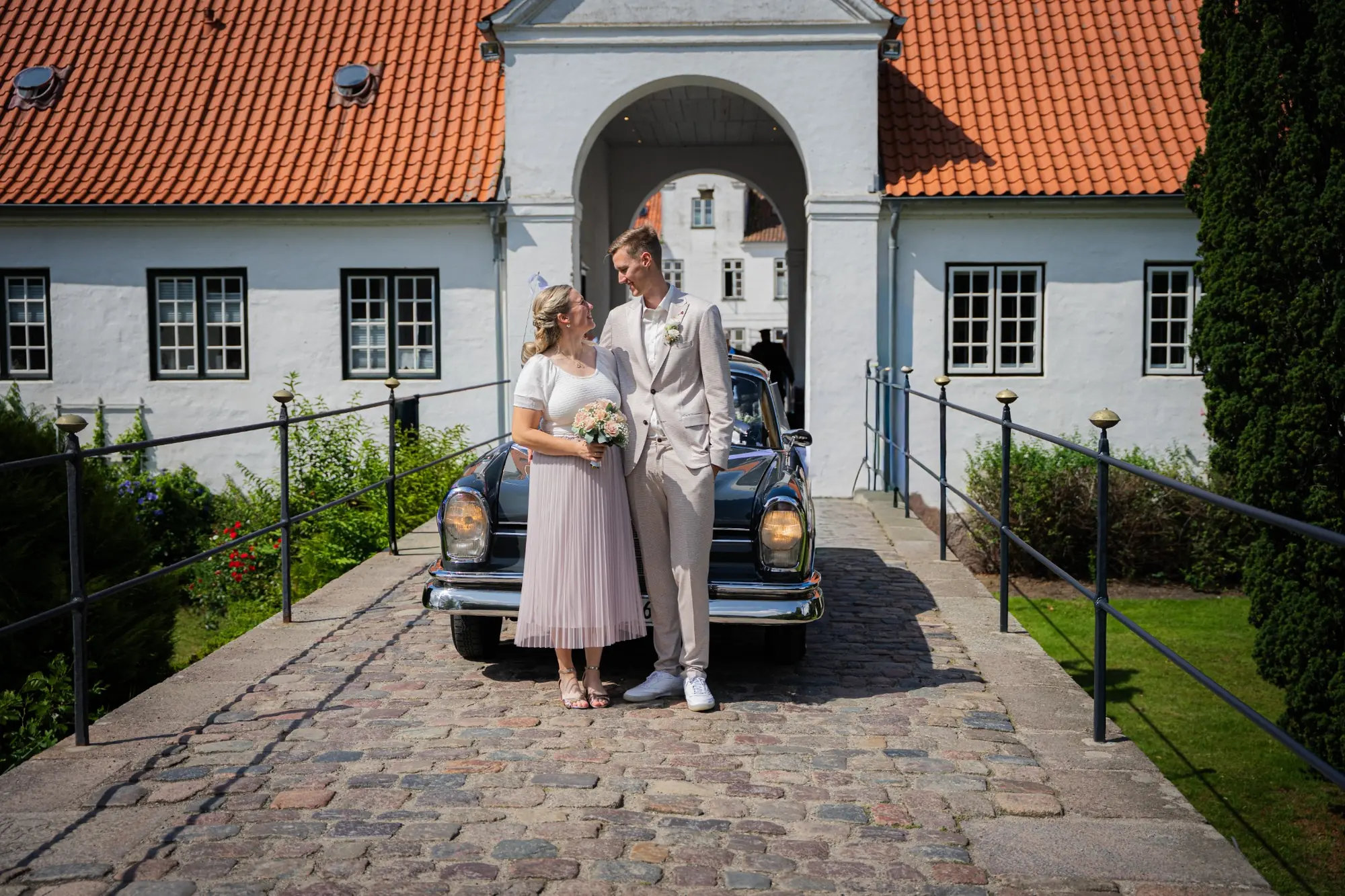 Brautpaar vor einem Schloss und einem Oldtimer