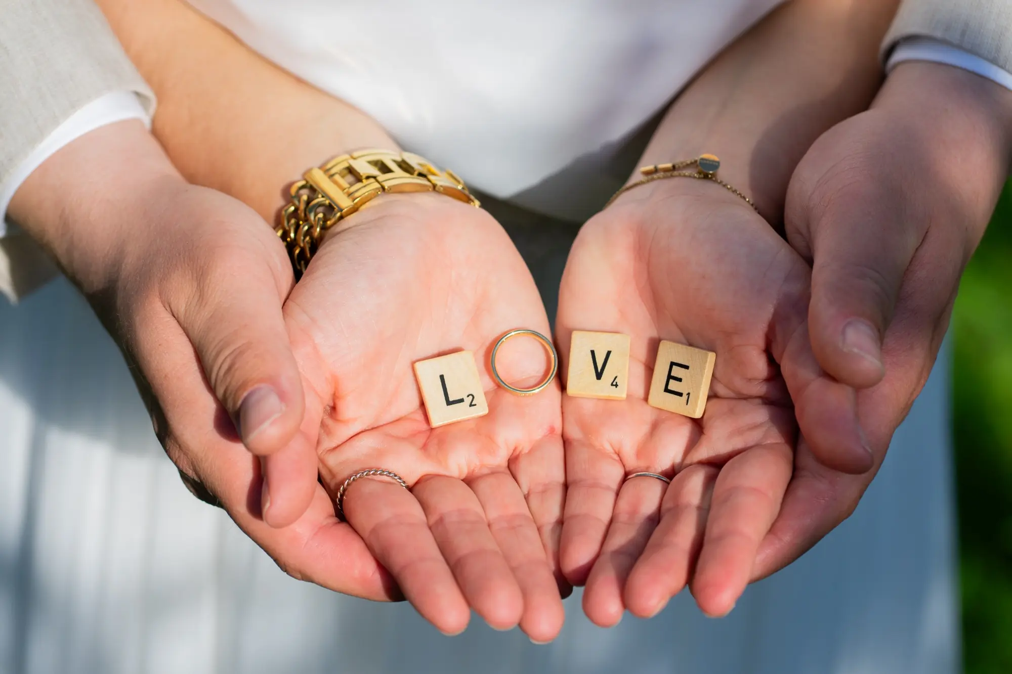 Hände eines Paares mit Ehering und dem Wort Love