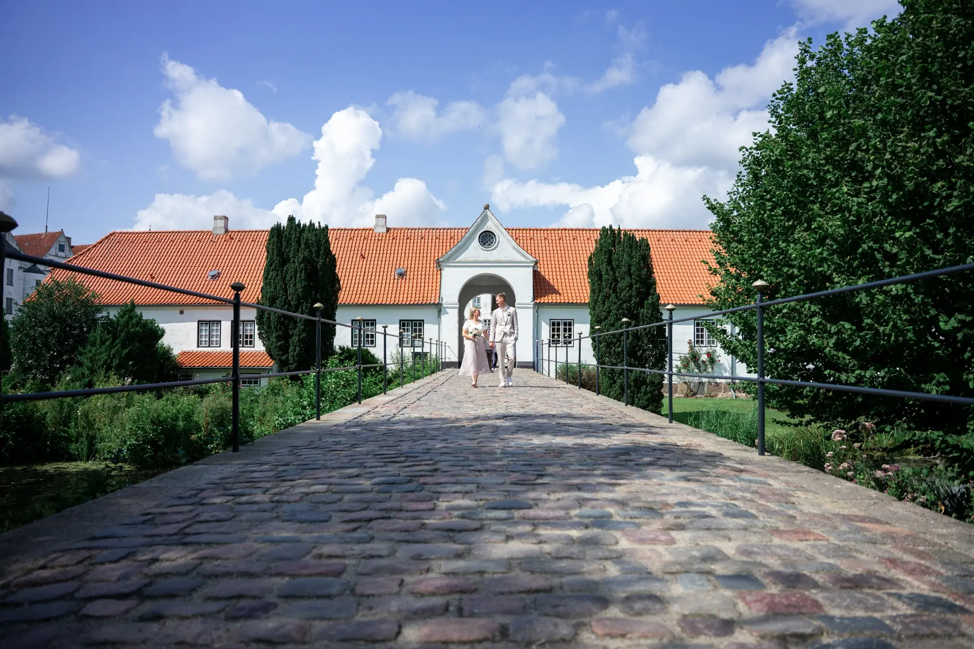 Brautpaar auf dem Weg vor einem Schloss