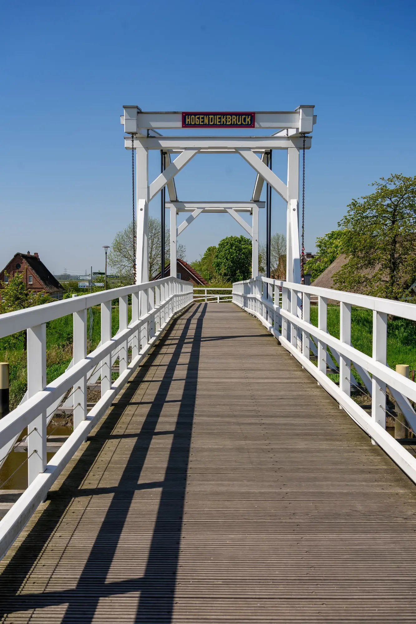 Weiße Holzbrücke unter blauem Himmel